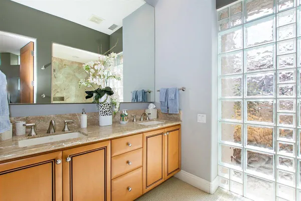 a bathroom with a granite countertop shower and a sink