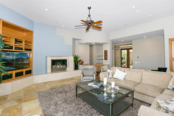 a living room with furniture a flat screen tv and a fireplace