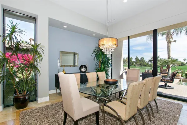 a living room with patio furniture and a potted plant