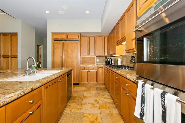a view of a kitchen with kitchen island a sink a counter top space and stainless steel appliances
