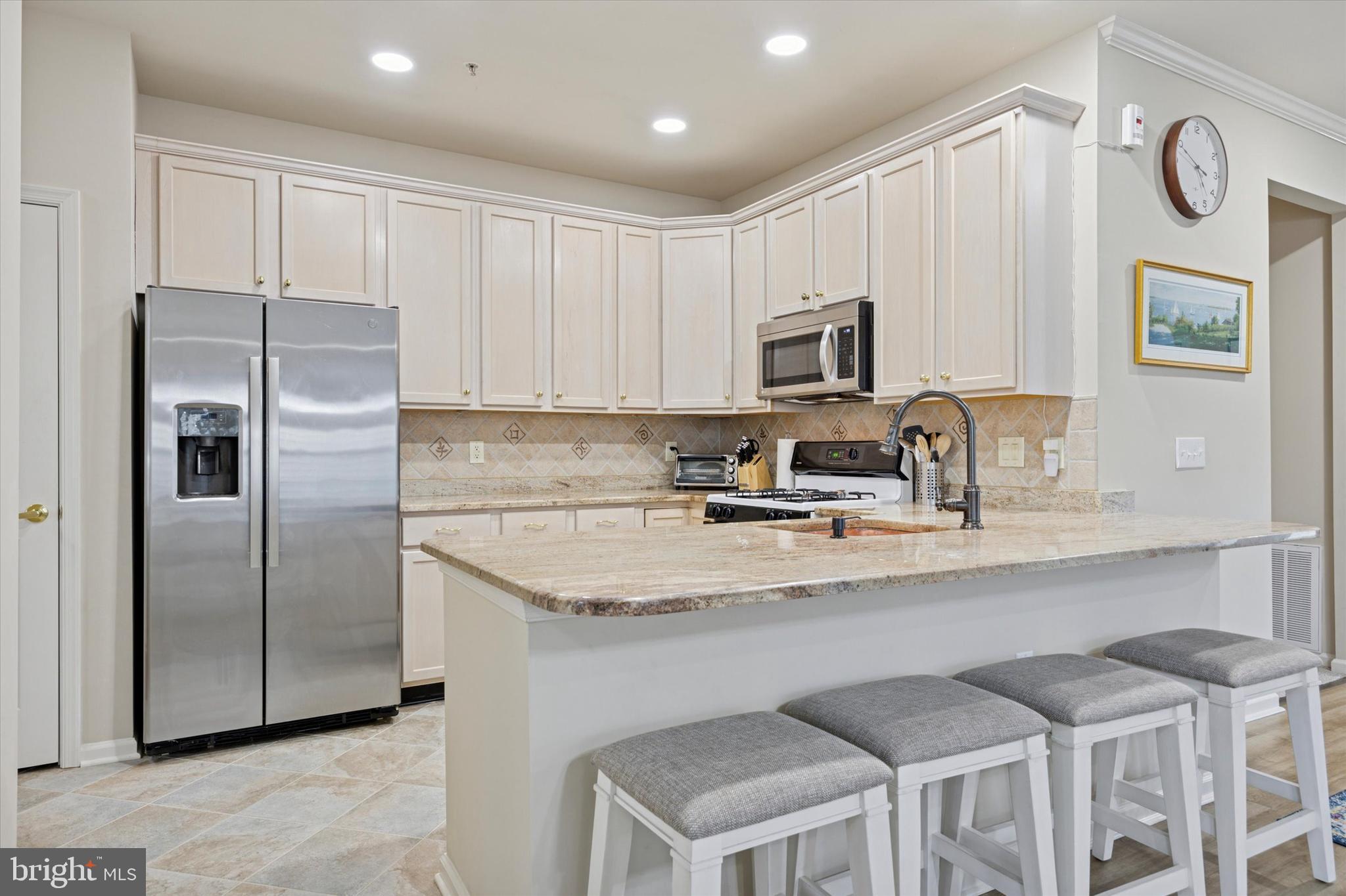 1105 Maxwell Manor Warminster, PA 18974 - Photo 6 of 15 a kitchen with stainless steel appliances granite countertop a refrigerator a sink a stove a microwave and island with wooden cabinets