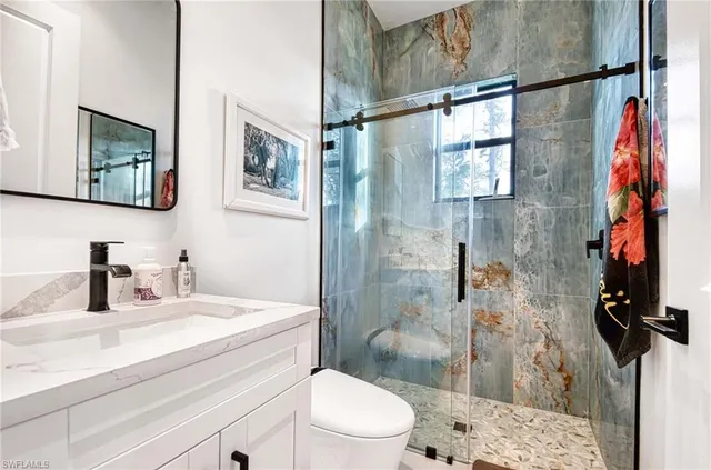 a bathroom with a sink a toilet and shower