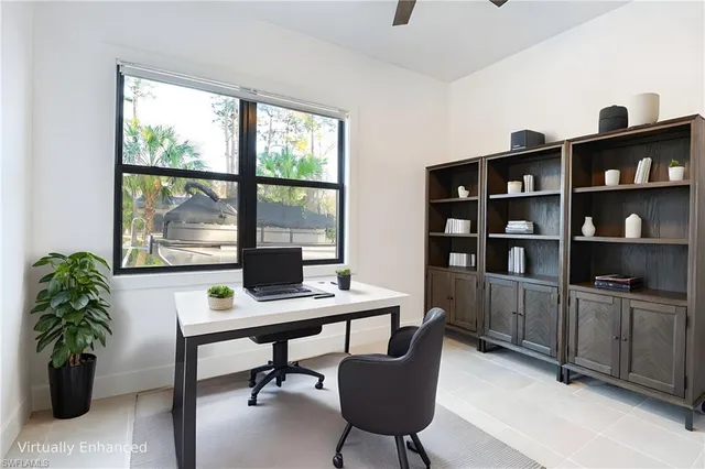 a view of a workspace with furniture and a window