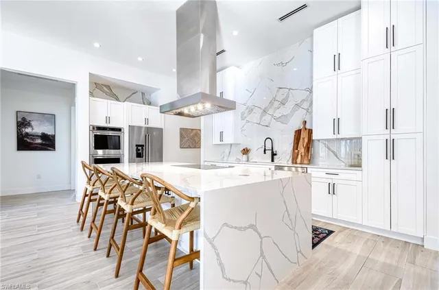 a kitchen with stainless steel appliances kitchen island granite countertop a sink and cabinets