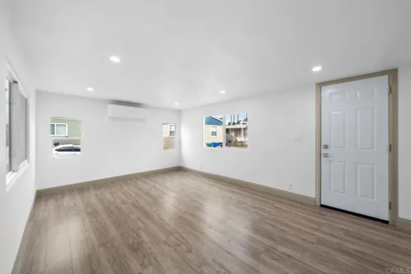 a view of a big room with wooden floor and windows