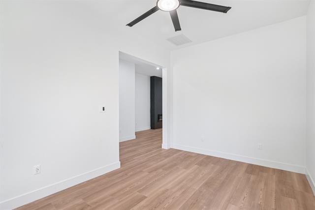2936 Henry Road Lancaster, TX 75134 - Photo 12 of 28 Light wood-finish flooring, white walls, and a contemporary black ceiling fan