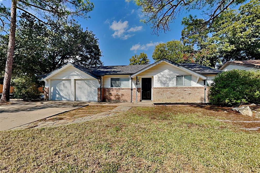 a view of a house with a yard and large tree