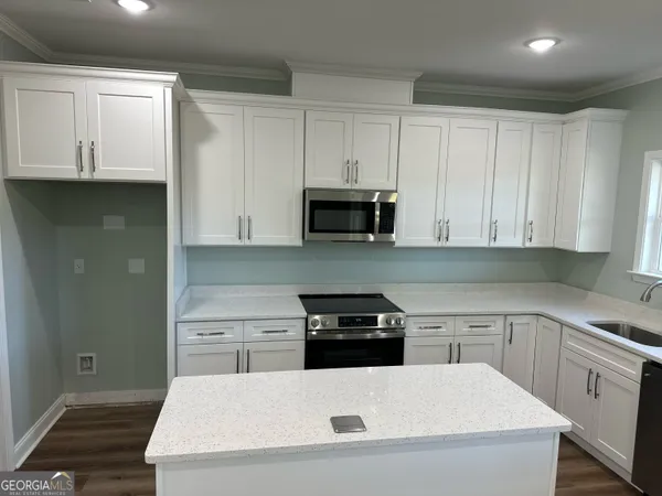 a kitchen with white cabinets and stainless steel appliances
