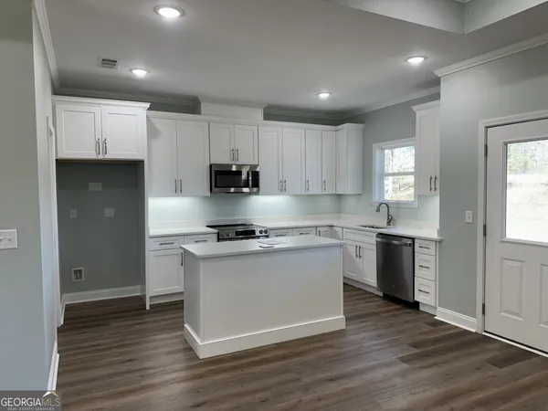 a kitchen with stainless steel appliances granite countertop a stove a sink and a refrigerator