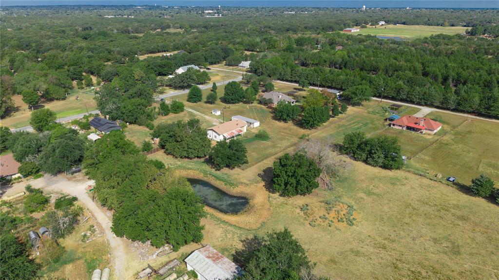 1214 Desvoignes Road Denison, TX 75021 - Photo 2 of 20 Expansive rural landscape featuring wooded areas, open fields, and a visible pond