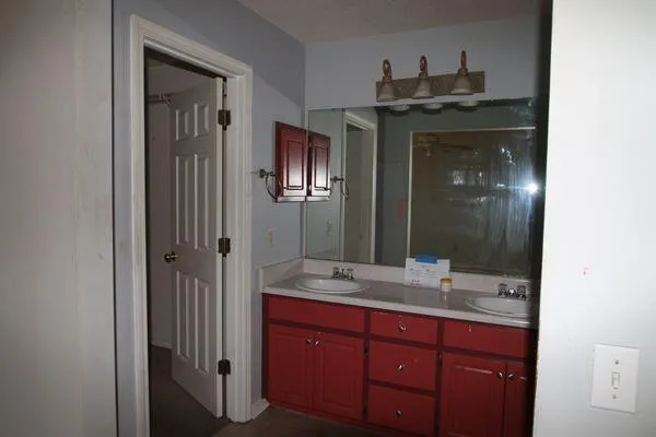 a bathroom with a granite countertop sink a mirror and a shower