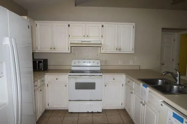 a kitchen with cabinets appliances a sink and a counter top