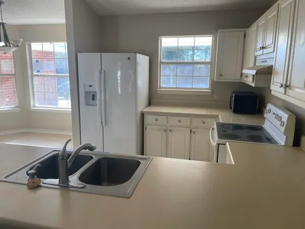 a kitchen with a sink a stove and a refrigerator