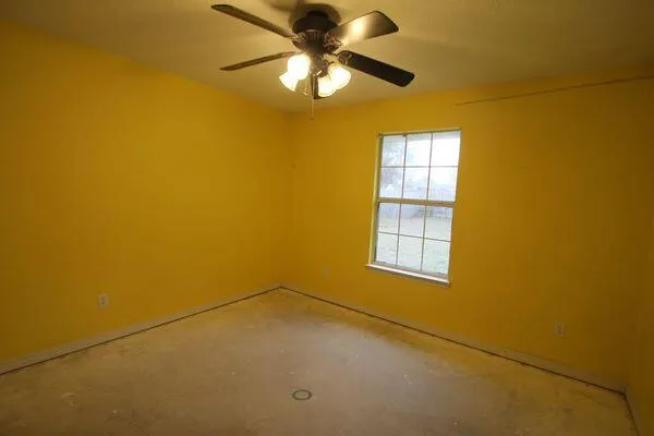 a view of a big room with windows and chandelier fan