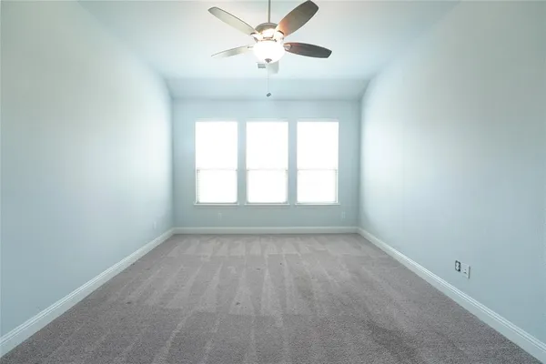 an empty room with a chandelier fan and a ceiling fan