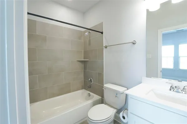 a bathroom with a tub sink vanity and mirror