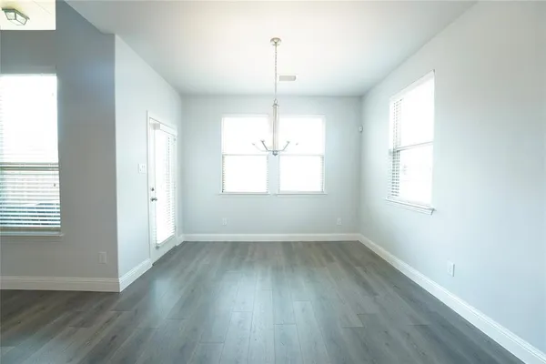 a large kitchen with cabinets wooden floor and stainless steel appliances