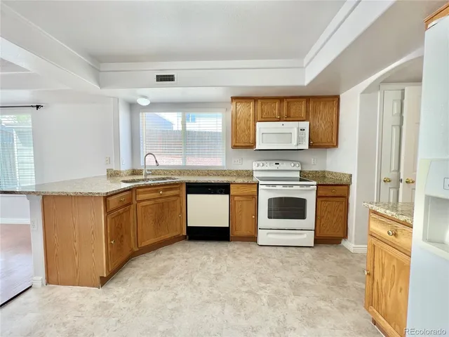 a kitchen with stainless steel appliances granite countertop a stove and a refrigerator