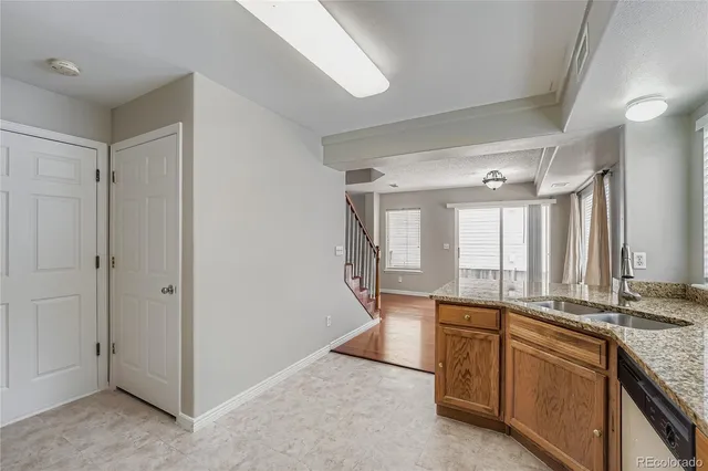 a view of a kitchen with a sink and dishwasher a refrigerator with wooden floor