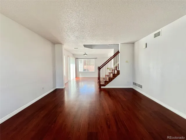 a hallway with wooden floor windows and stairs