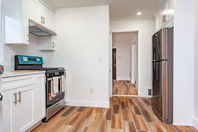 a kitchen with stainless steel appliances granite countertop a refrigerator a stove and a sink