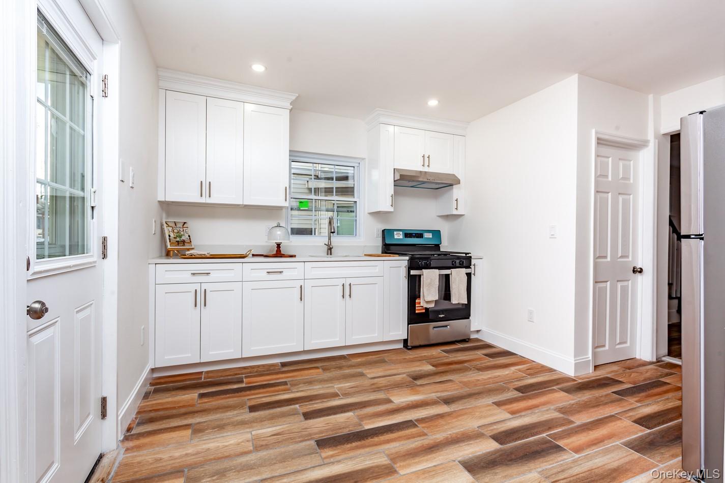 89 Smith Street Poughkeepsie, NY 12601 - Photo 13 of 42 a kitchen with a refrigerator and white cabinets