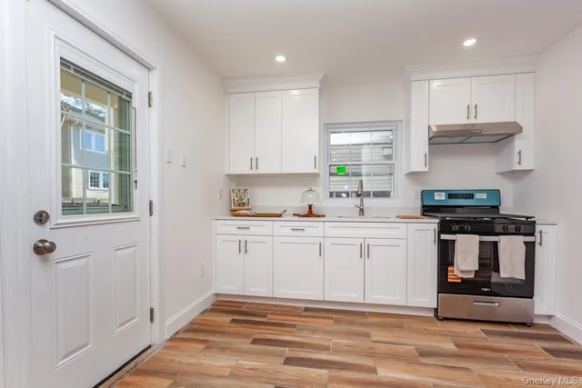 a kitchen with stainless steel appliances granite countertop a stove a sink and a refrigerator