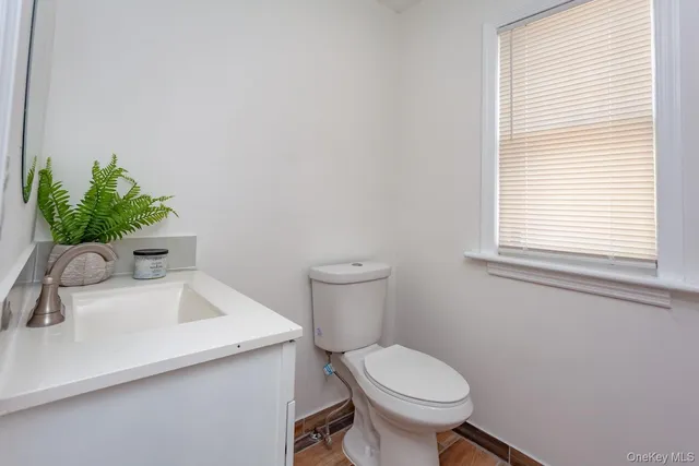 a bathroom with a sink toilet and window