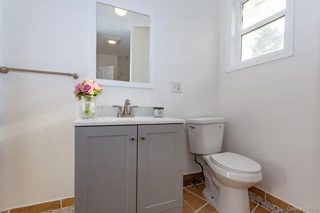 a bathroom with a toilet sink vanity and mirror