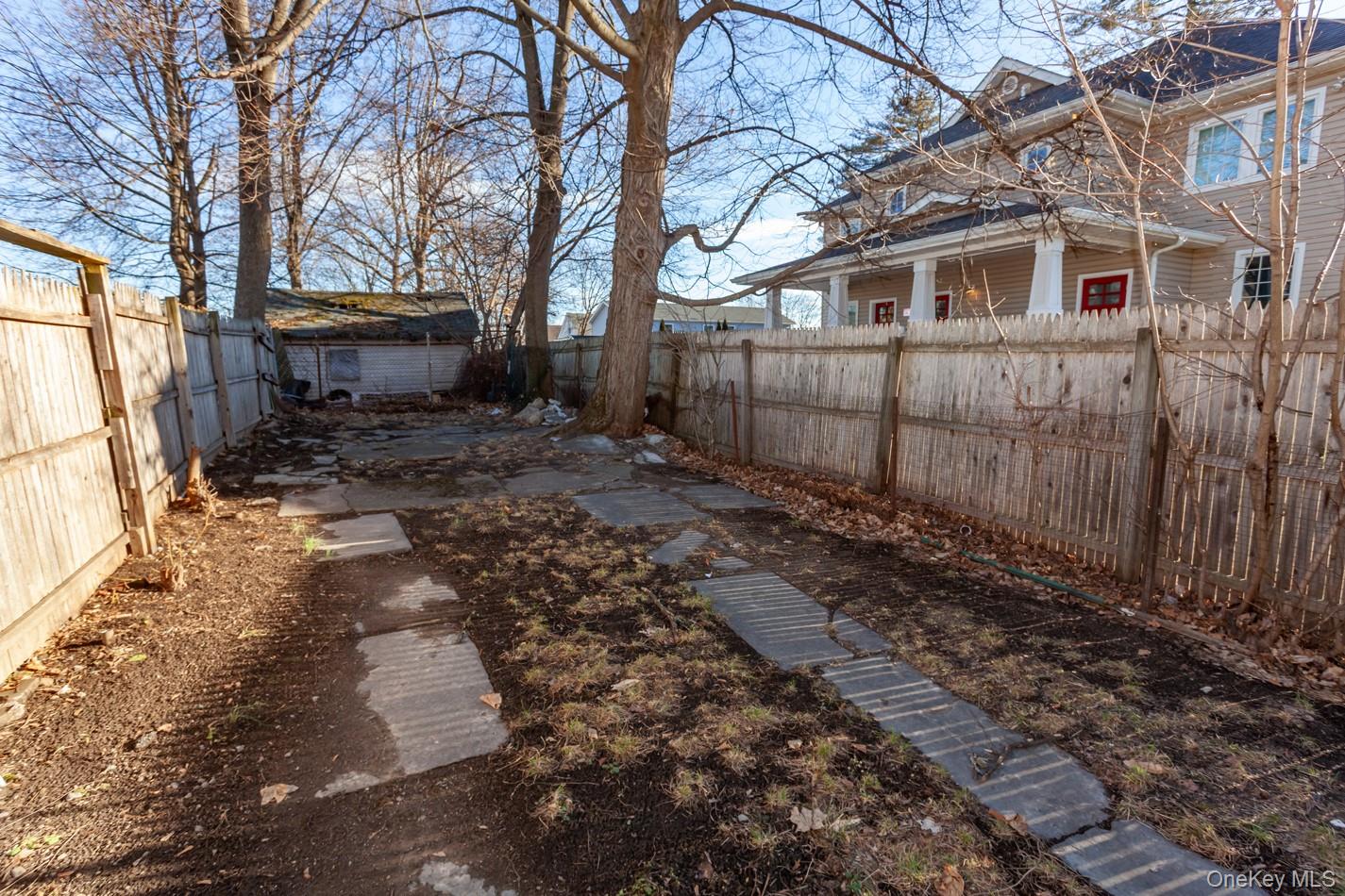 89 Smith Street Poughkeepsie, NY 12601 - Photo 39 of 42 a view of a backyard with large trees and wooden fence