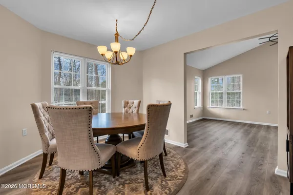 a view of a dining room with furniture a chandelier and wooden floor