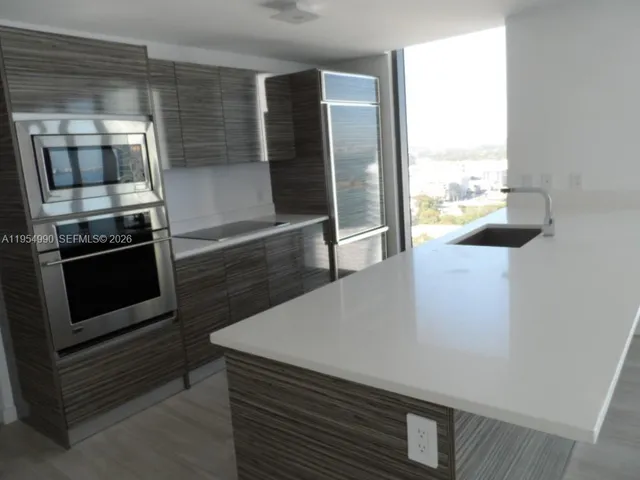 a kitchen with granite countertop a stove and a microwave