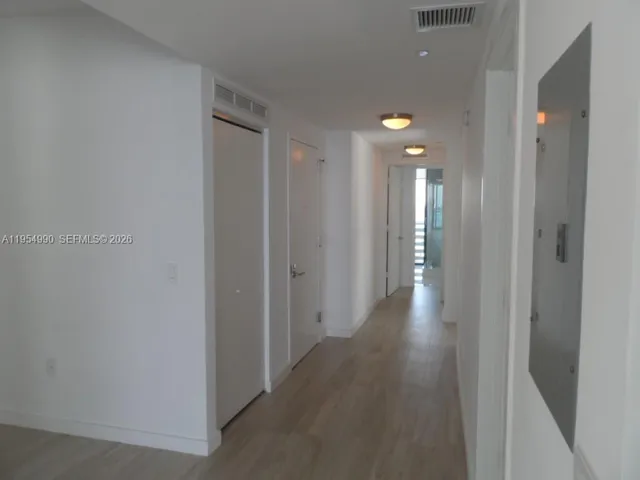 a view of a room with wooden floor and floor to ceiling window