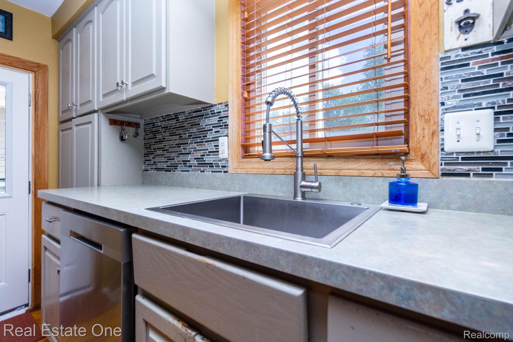 220 Winry Drive Rochester, MI 48307 - Photo 12 of 35 Kitchen featuring light gray cabinetry, a stainless steel sink with a pull-down faucet, and a mosaic tile backsplash