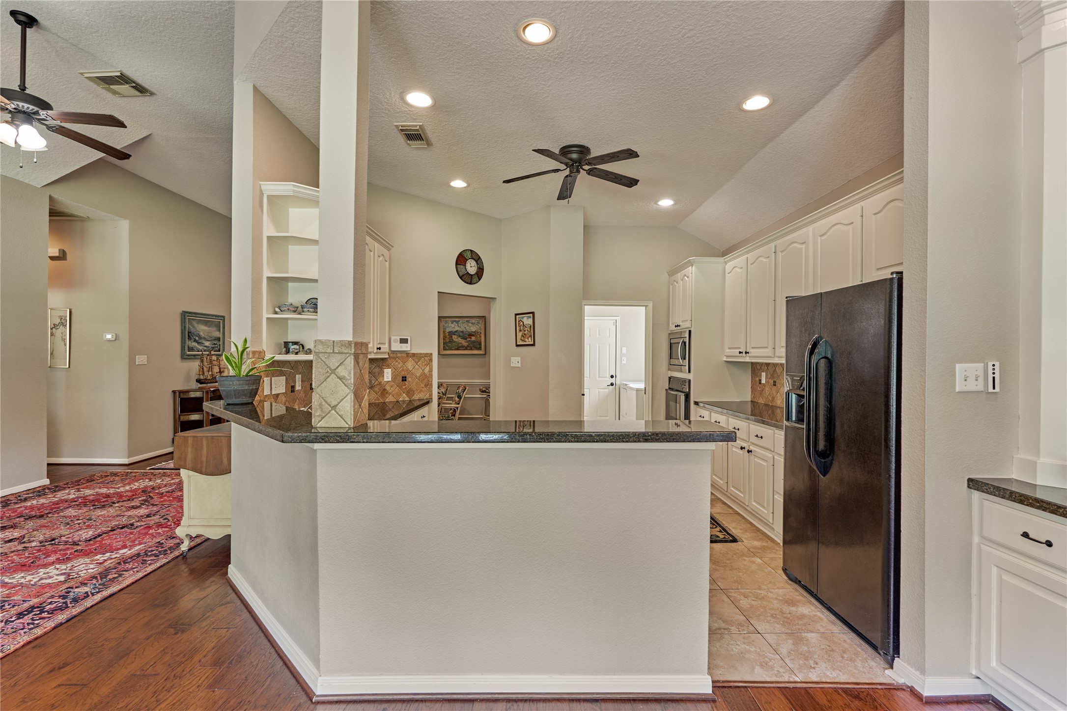 197 Monterrey Road East Montgomery, TX 77356 - Photo 14 of 50 The chef’s kitchen features a generous breakfast island, a gas cooktop, and extensive counter space and cabinetry, offering abundant storage and functionality.