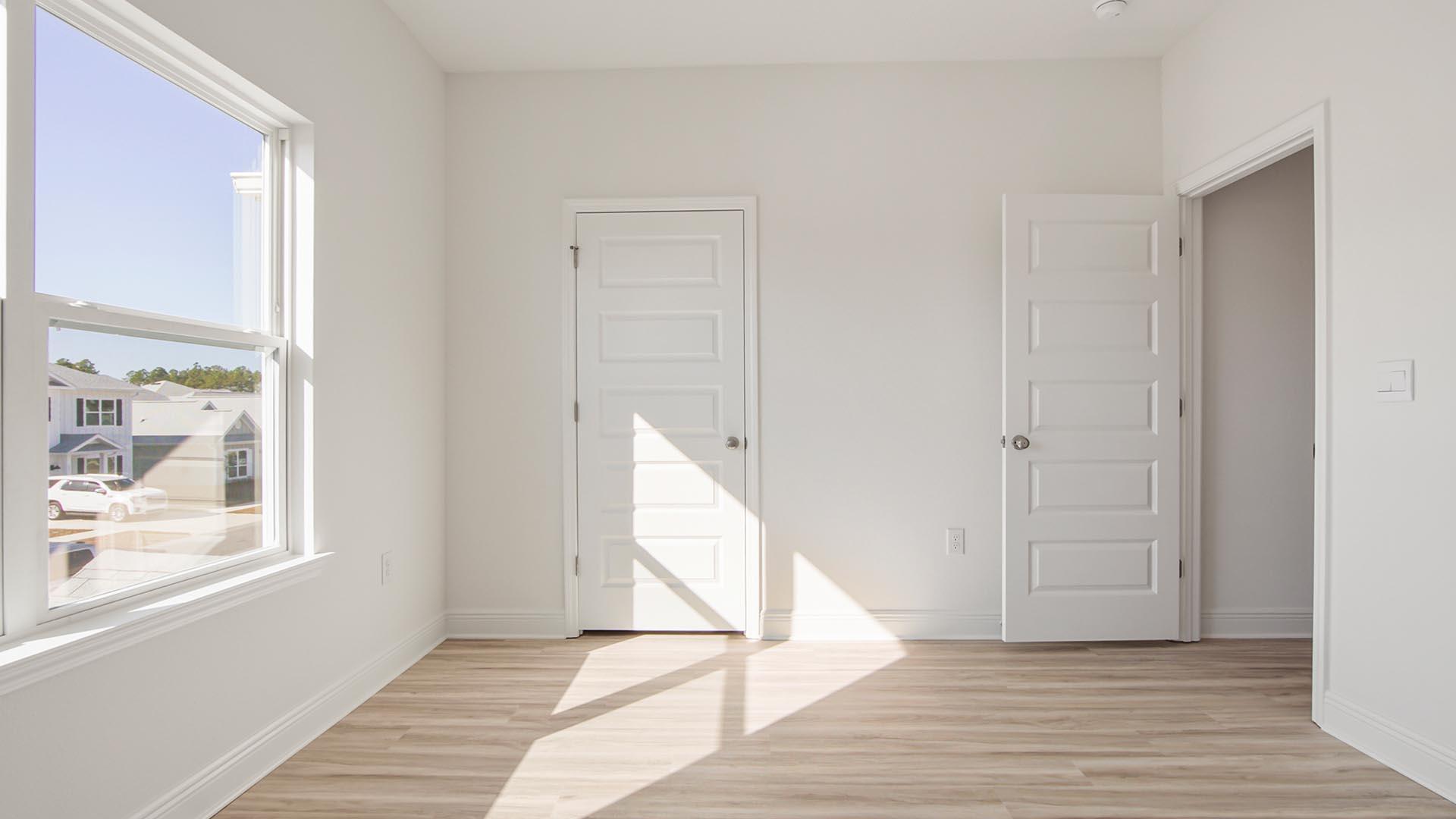 373 Holley Grv Lane Santa Rosa Beach, FL 32459 - Photo 37 of 46 a view of an empty room with wooden floor and a window