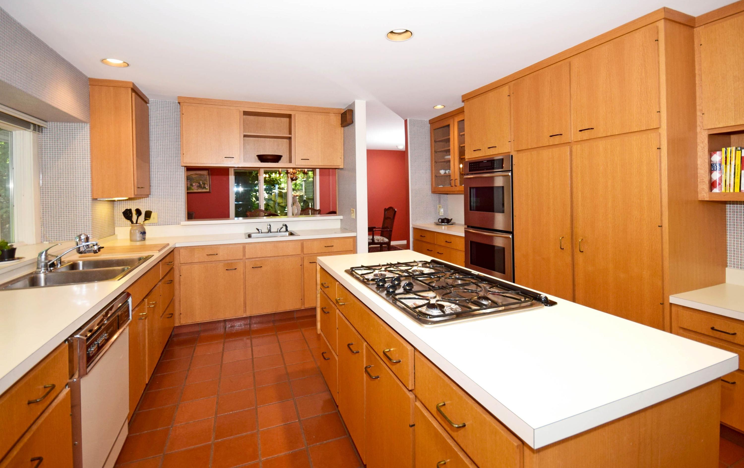 11 Wildcat Road Darien, CT 06820 - Photo 14 of 25 a kitchen with stainless steel appliances a sink a stove a refrigerator cabinets and a dining table