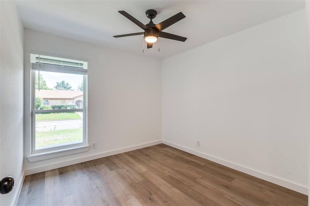 1101 Spring Brook Drive Bedford, TX 76021 - Photo 13 of 17 an empty room with wooden floor and windows