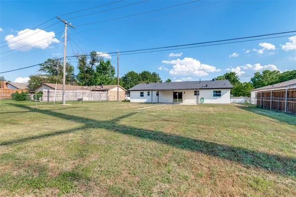 a view of a house with backyard and a tree