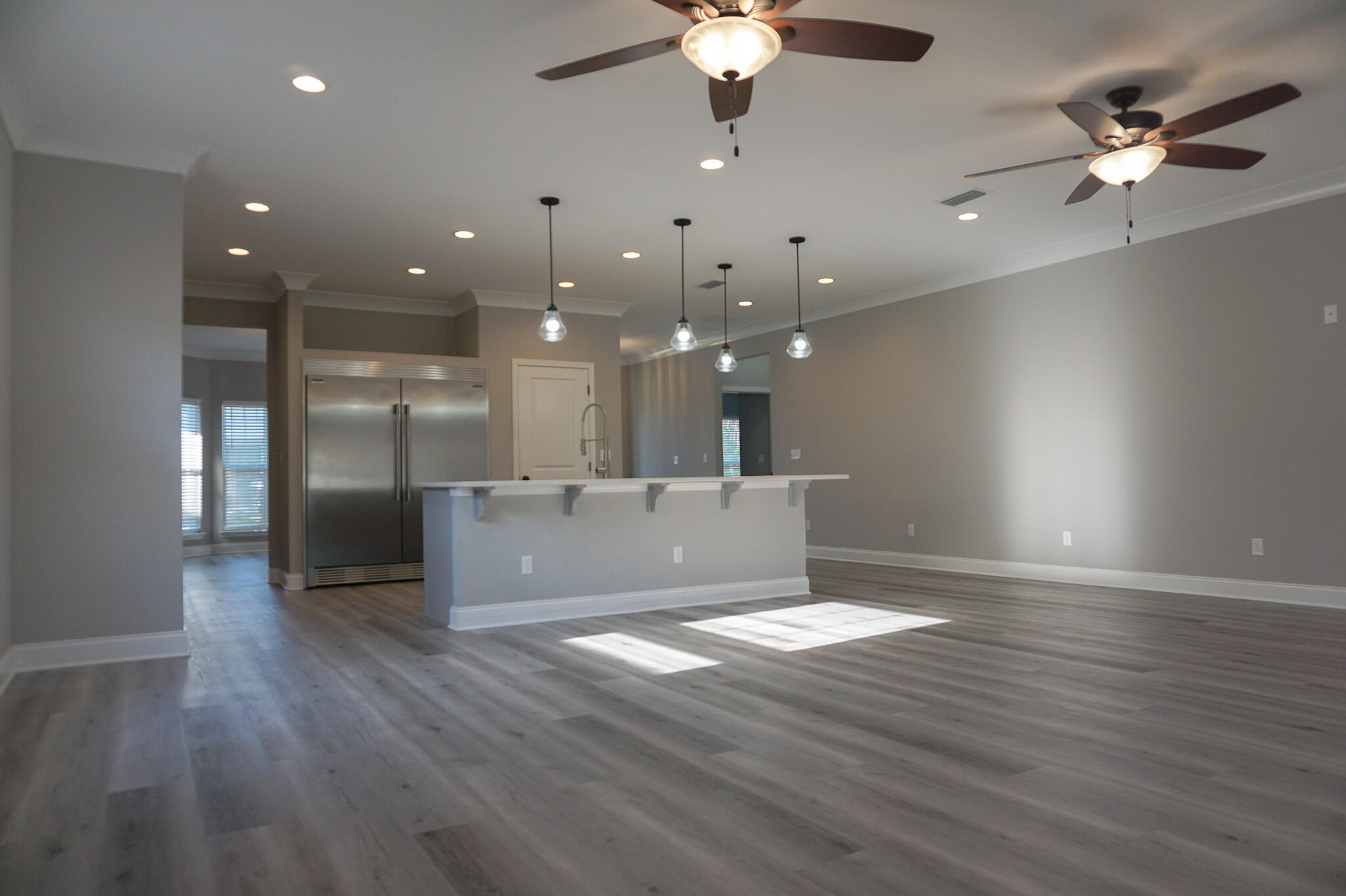 48 9th Avenue Shalimar, FL 32579 - Photo 16 of 60 an empty room with wooden floor a ceiling fan a ceiling fan and kitchen view