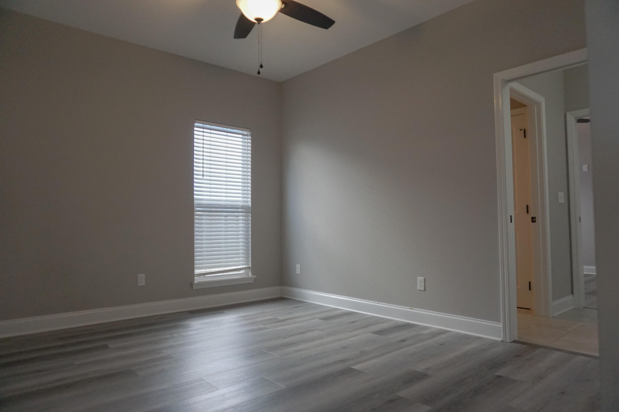 48 9th Avenue Shalimar, FL 32579 - Photo 39 of 60 an empty room with wooden floor chandelier fan and windows