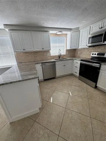 a kitchen with a stove a microwave and a sink
