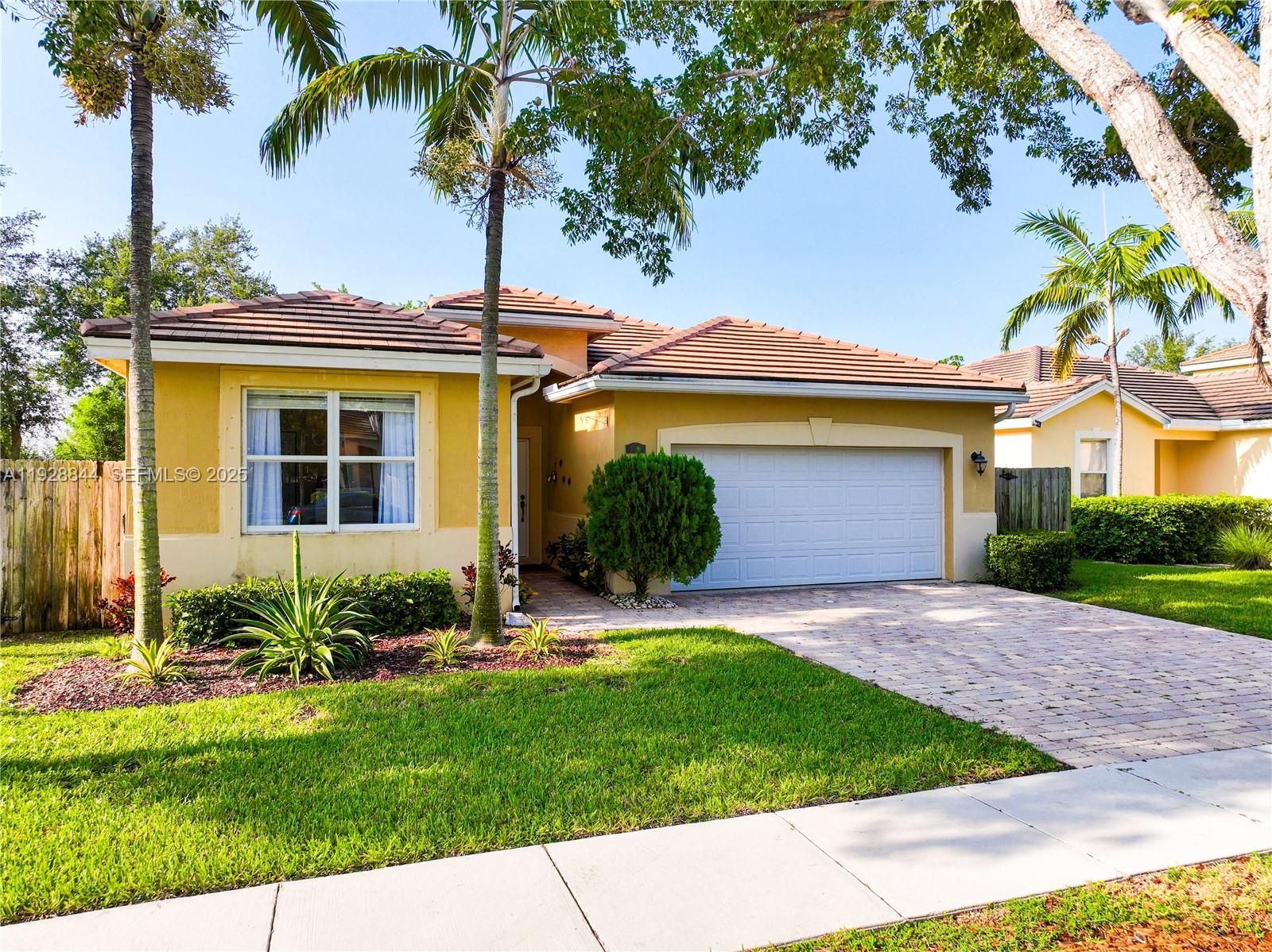 a view of a house with a yard and palm trees