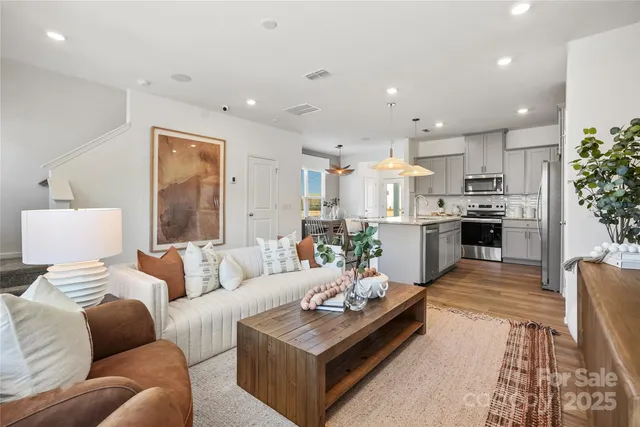 a living room with furniture and kitchen view
