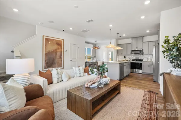 a living room with furniture kitchen and a table