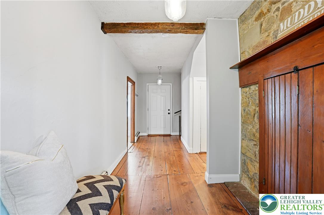 2014 Linden Street Bethlehem, PA 18017 - Photo 9 of 85 A well-lit entry hall features exposed wooden beams and rich hardwood flooring, leading to a classic white door.