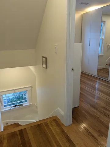 a view of a white house with large windows and a yard