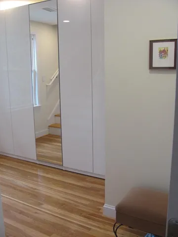 a view of a white house with large windows and a yard