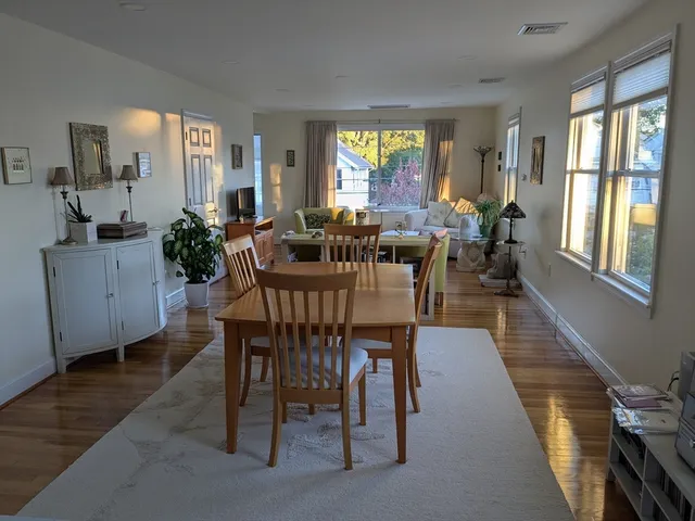 a view of a dining room with furniture a livingroom and chandelier