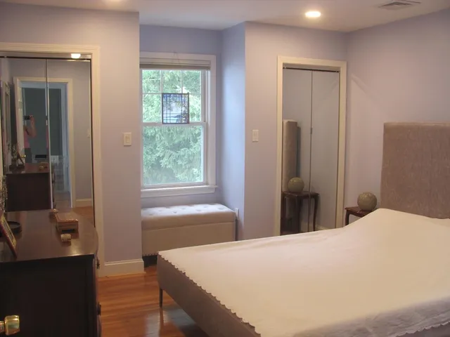 a bedroom with a bed and a flat tv screen next to a window